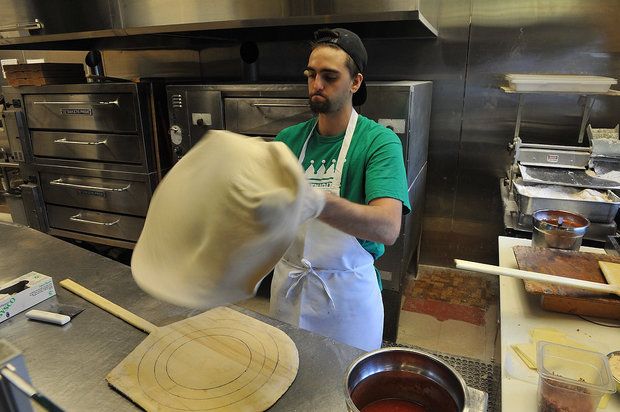 Davenport's Pizza opening new Vestavia location 2 Man wearing green shirt and white apron in kitchen spinning pizza dough