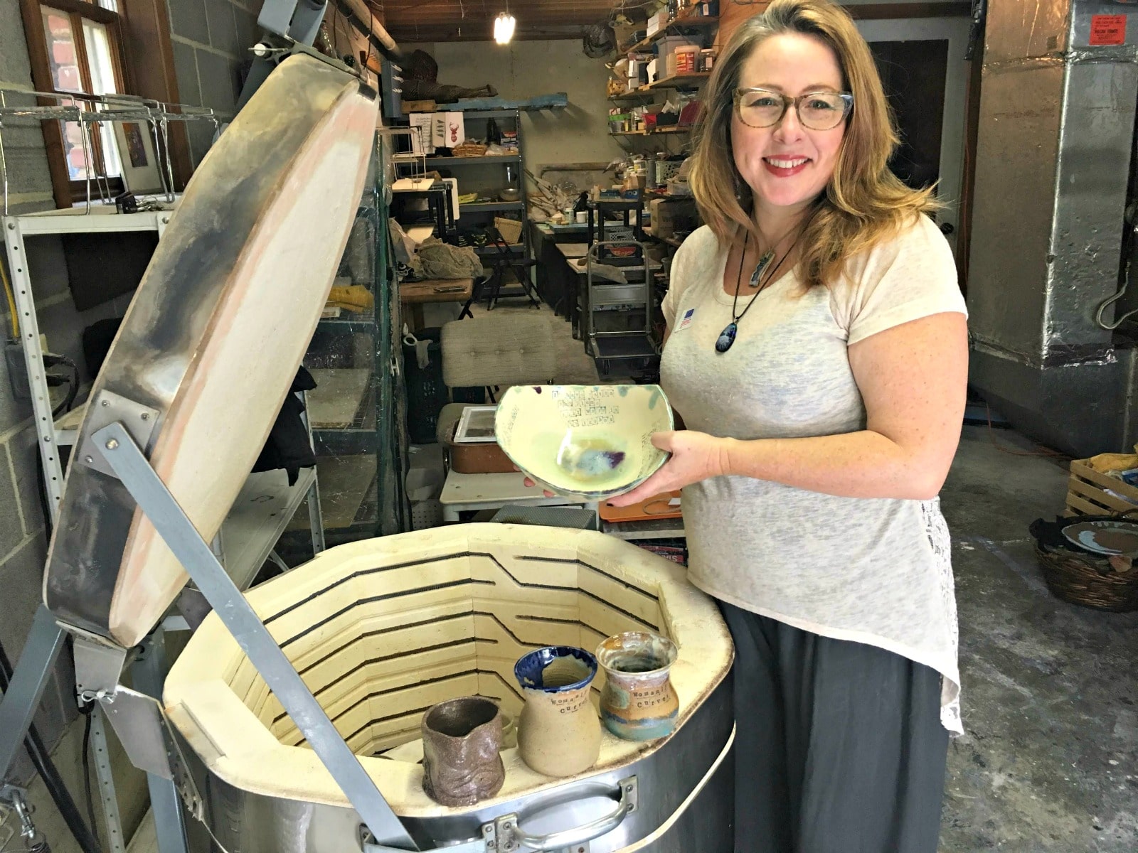 One of the Roebuck Springs potters, Nichole Lariscy Moore, with finished work near her kiln. 