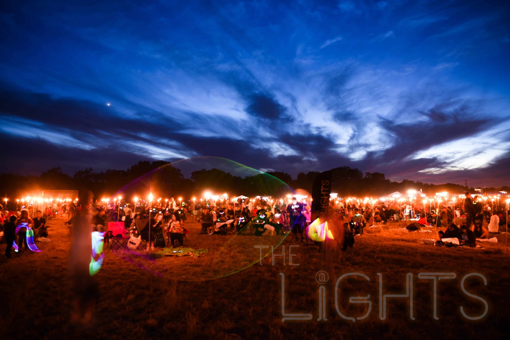 Tiki torches light the grounds as festival goers wait for nightfall. (Photo via The Lights Fest)