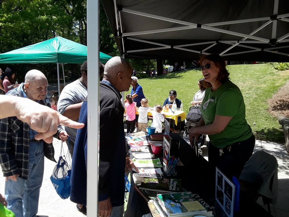 Two older gentlemen visit with a Birmingham Botanical Gardens representative at a previous Earth Day event 