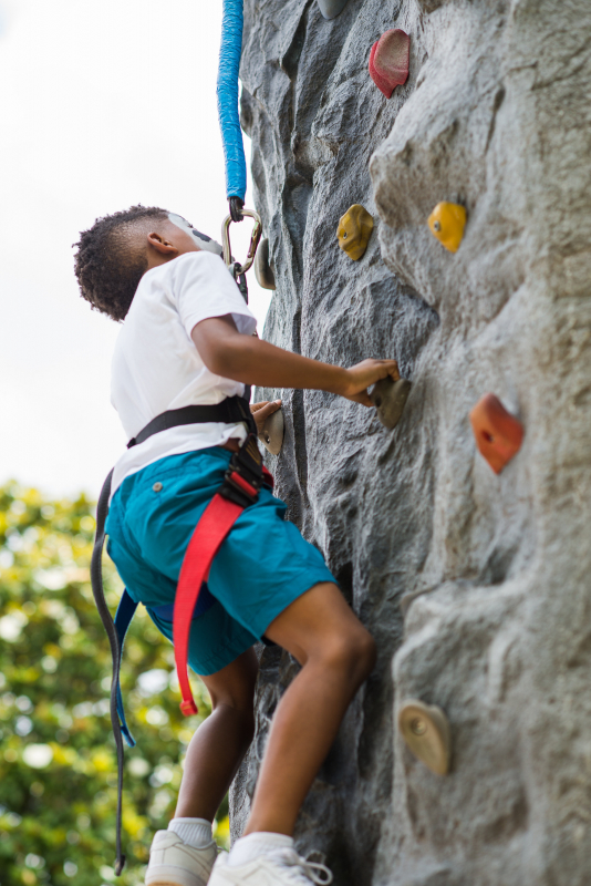 Kid on rock climbing wall at Vulcan Park's Birthday Bash