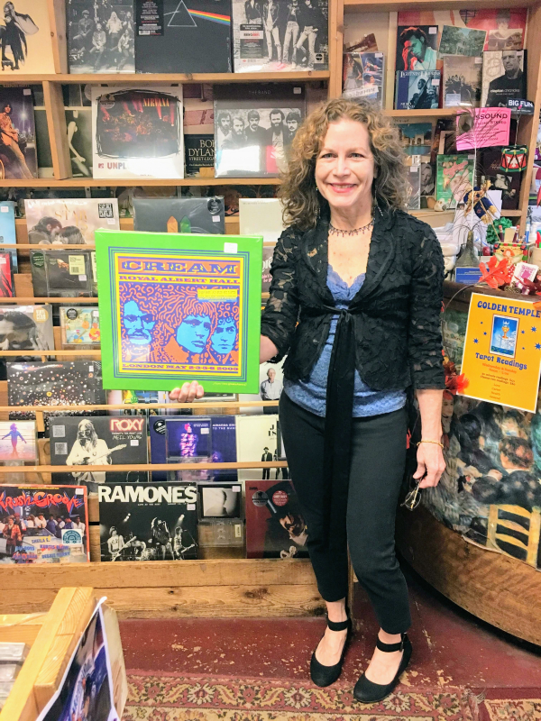 Marian McKay Rosato of Charlemagne Record Exchange, holding an expensive item from the store. 