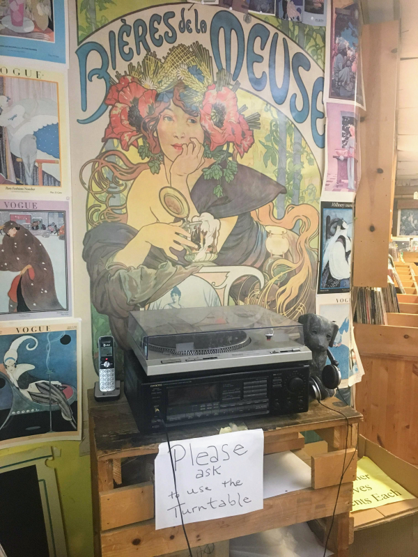 A hand written sign reads "please ask to use the turntable."