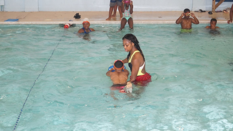 Woman teaching child how to swim