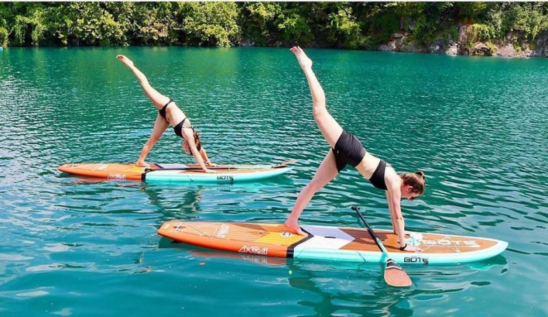 Two women doing paddle board yoga