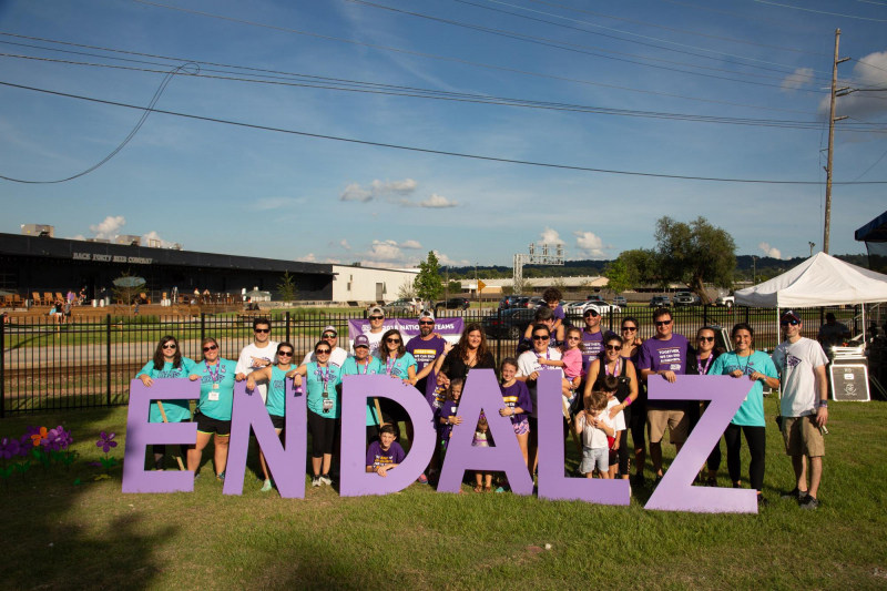 Participant of the Walk to End Alzheimer's hold up END ALZ sign at Sloss Furnaces in Birmingham, Alabama