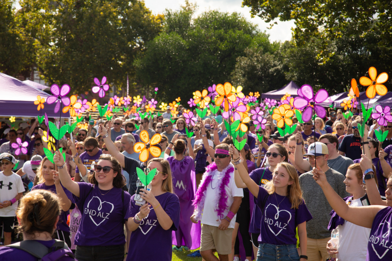 People hold up Promise Flowers at Walk to End Alzheimer's
