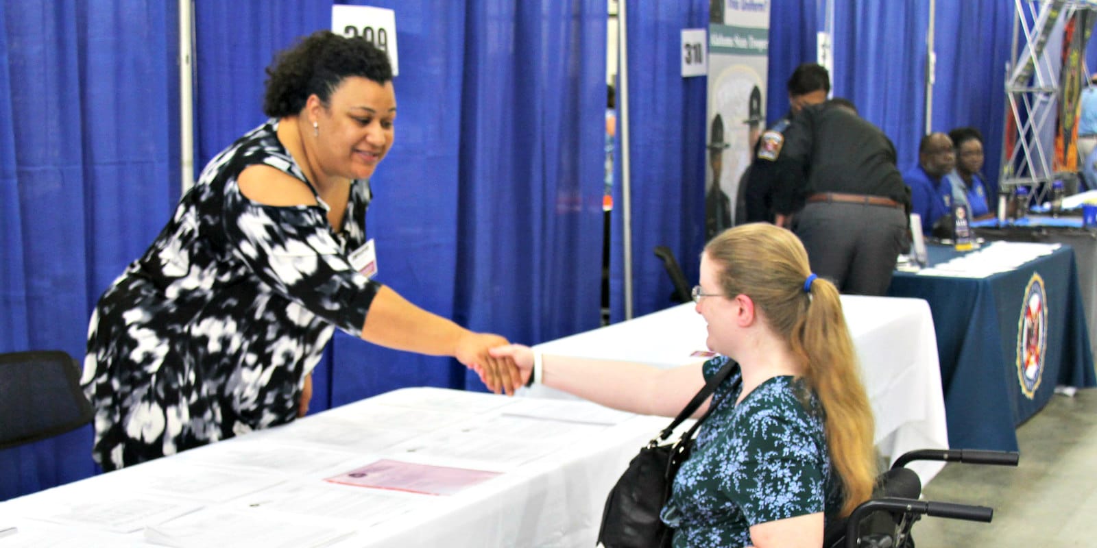 Alabama Department of Rehabilitation Services working with a participant in a wheelchair at a job fair