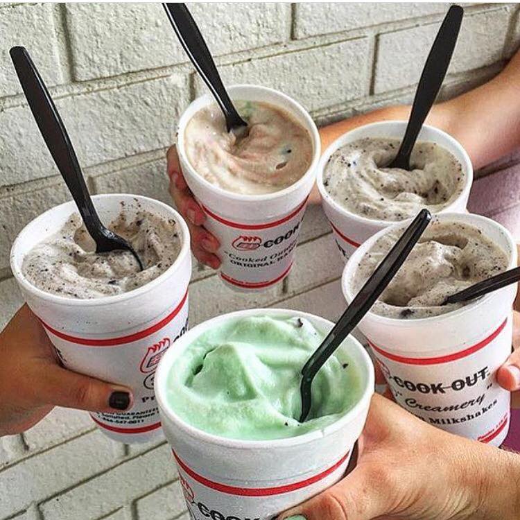 People hold out their milkshakes in a circle