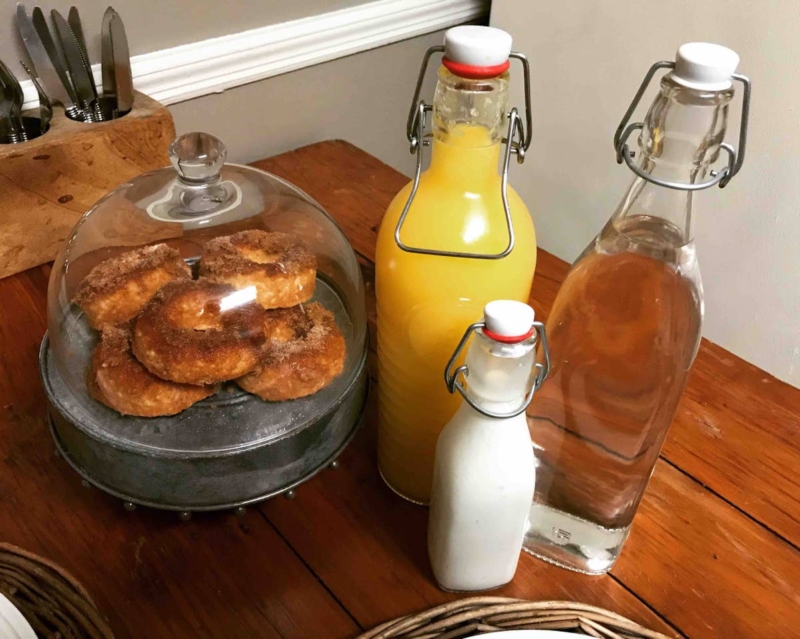 Donuts and orange juice on a counter.
