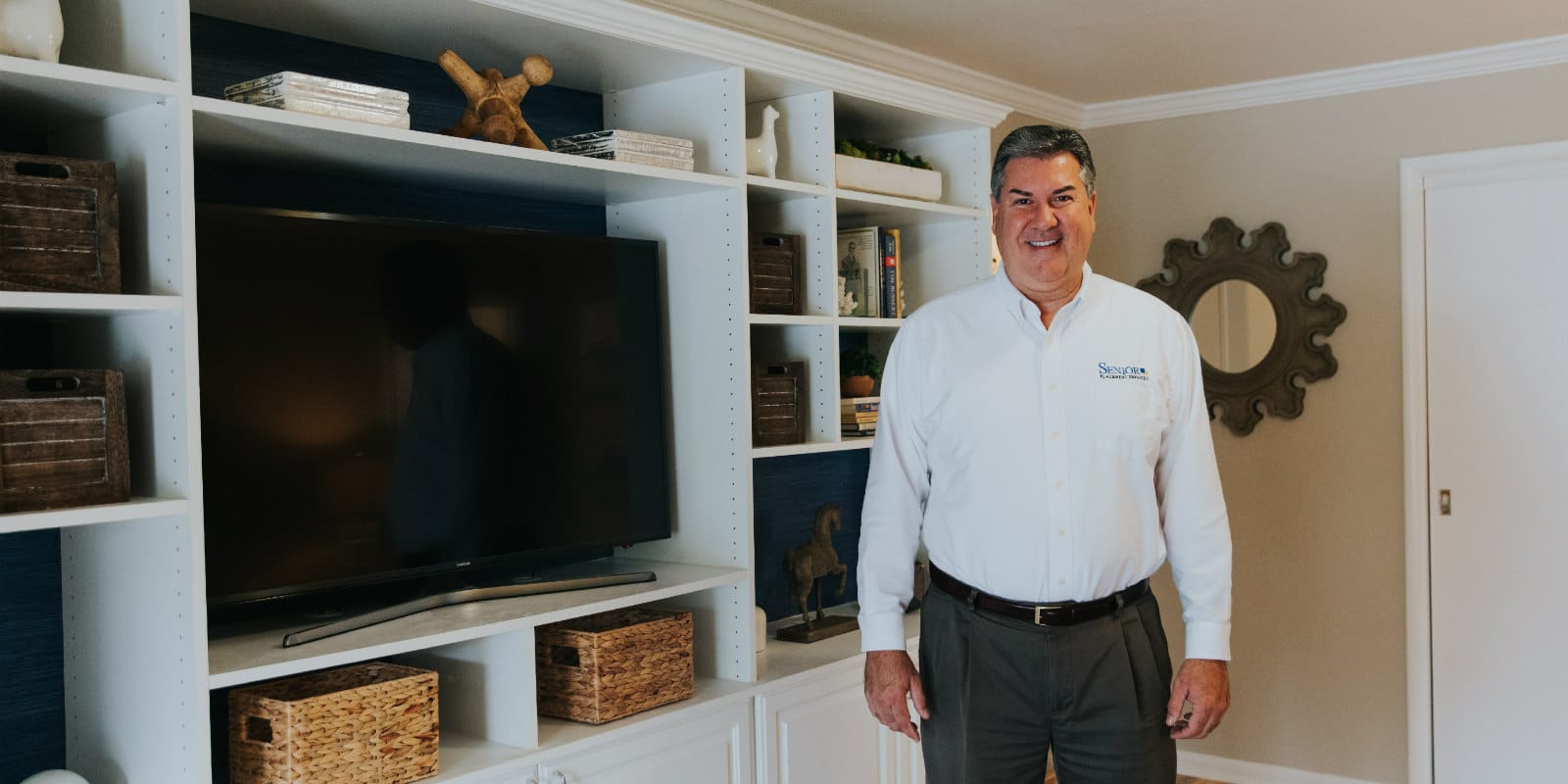 Photo of Tim Meehan in front of his  built-in entertainment center by Closets by Design