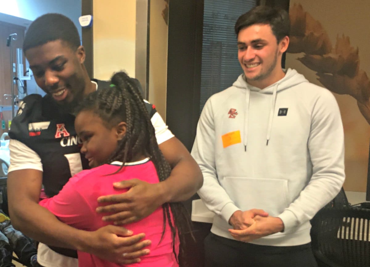 Football players and Children's of Alabama patient