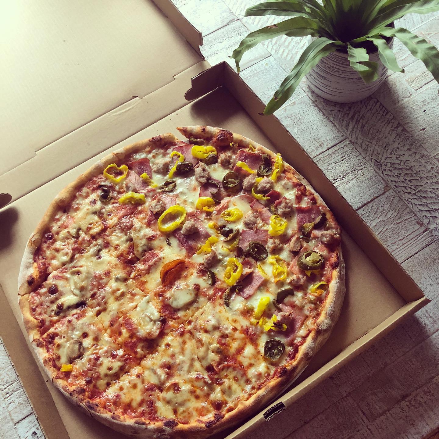 Pizza inside a box with a variety of toppings