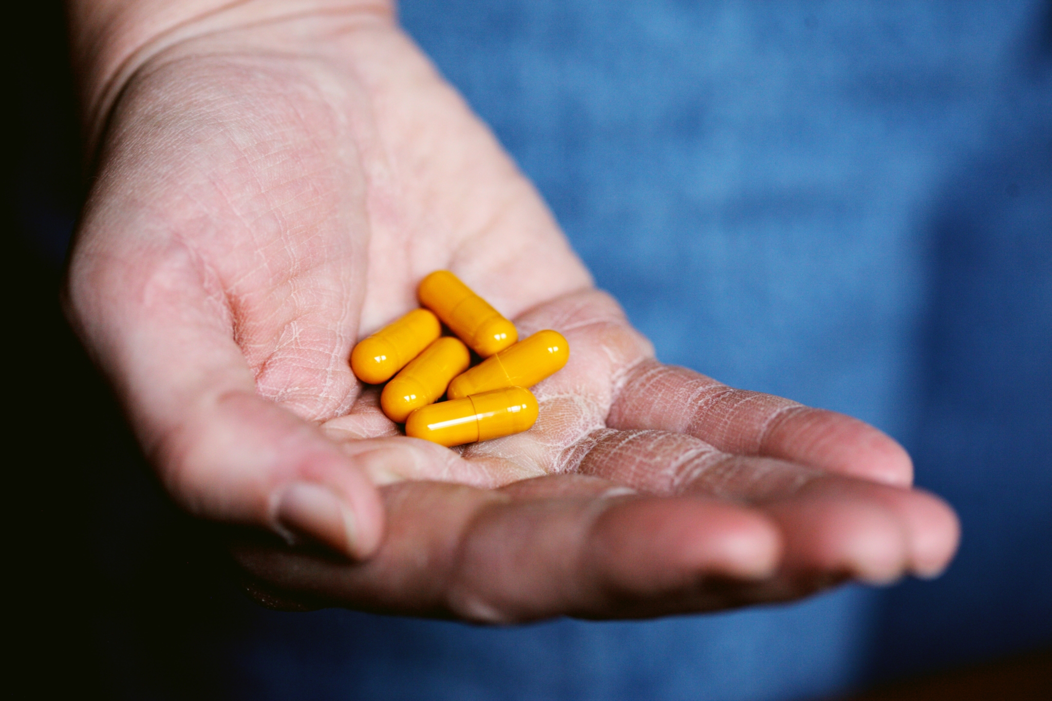 yellow medication pill on persons hand, boost immune system BlueCross, boost your immune system