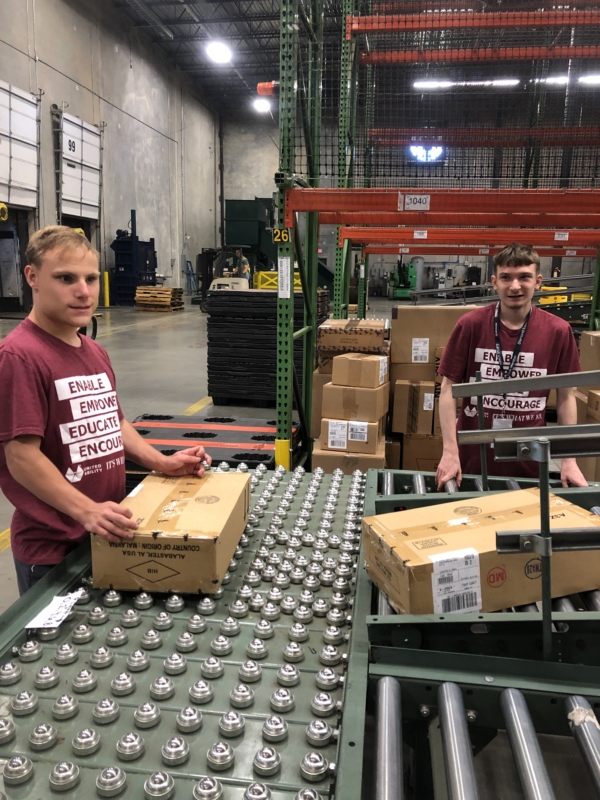 Two United Ability Students pose while working at the Hibbett warehouse in Birmingham. 