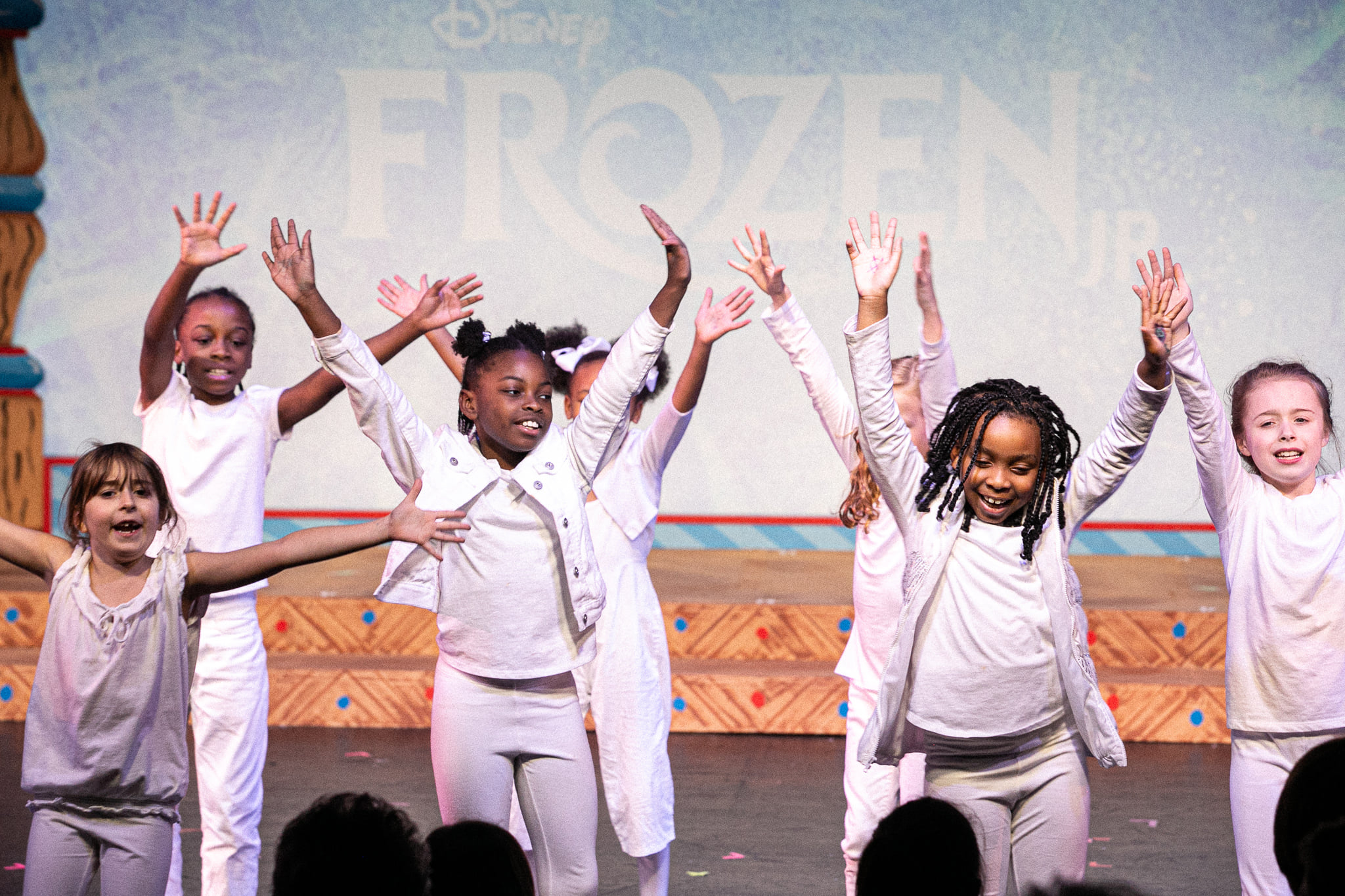 Children in white performing for a Red Mountain Theatre performance