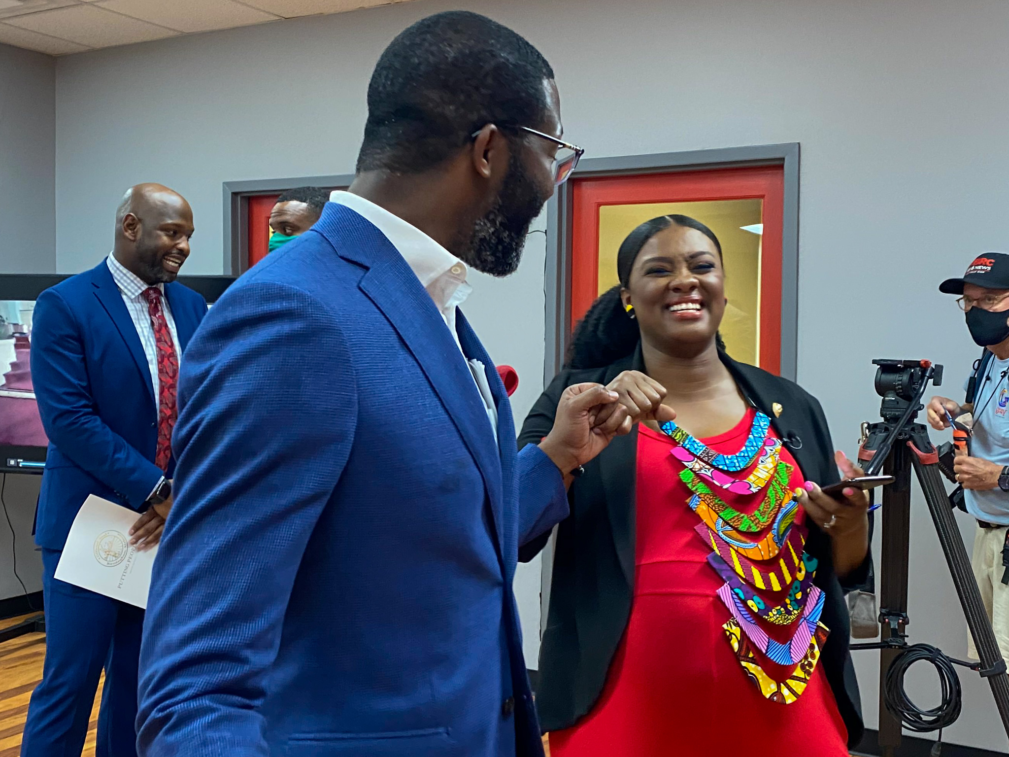 Mayor Woodfin fist bumps Ursula Smith, who will be featured in the Pricelesscampaign. Photo via Libby Foster for Bham Now