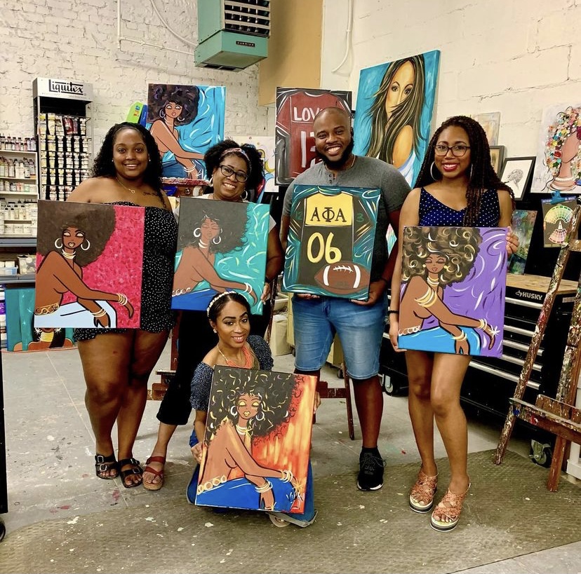 group of people holding paintings from the art class