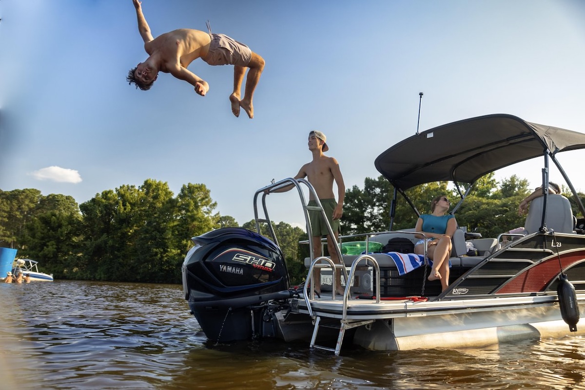 A young man backflips from a boat into the water at Ross Barnett Reservoir in Ridgeland, Mississippi.