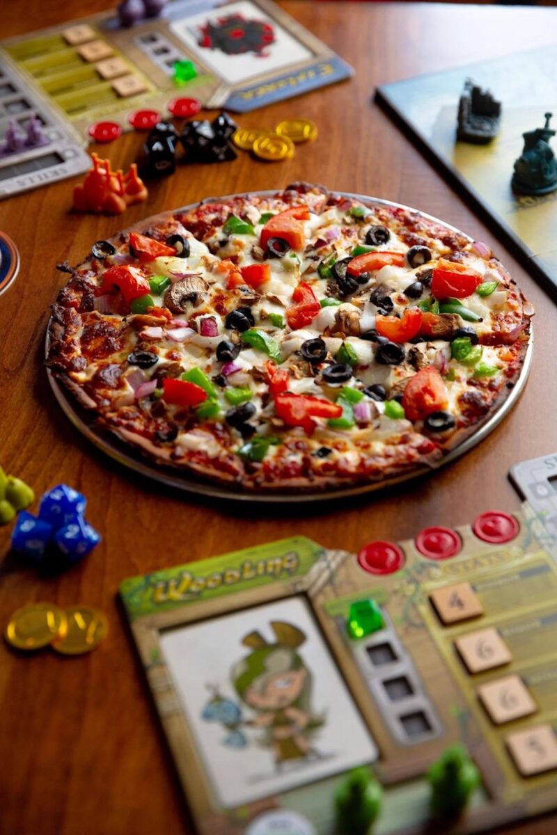 Gaming boards surround a pizza in the center of a table at Dogmud Tavern in Ridgeland, Mississippi.