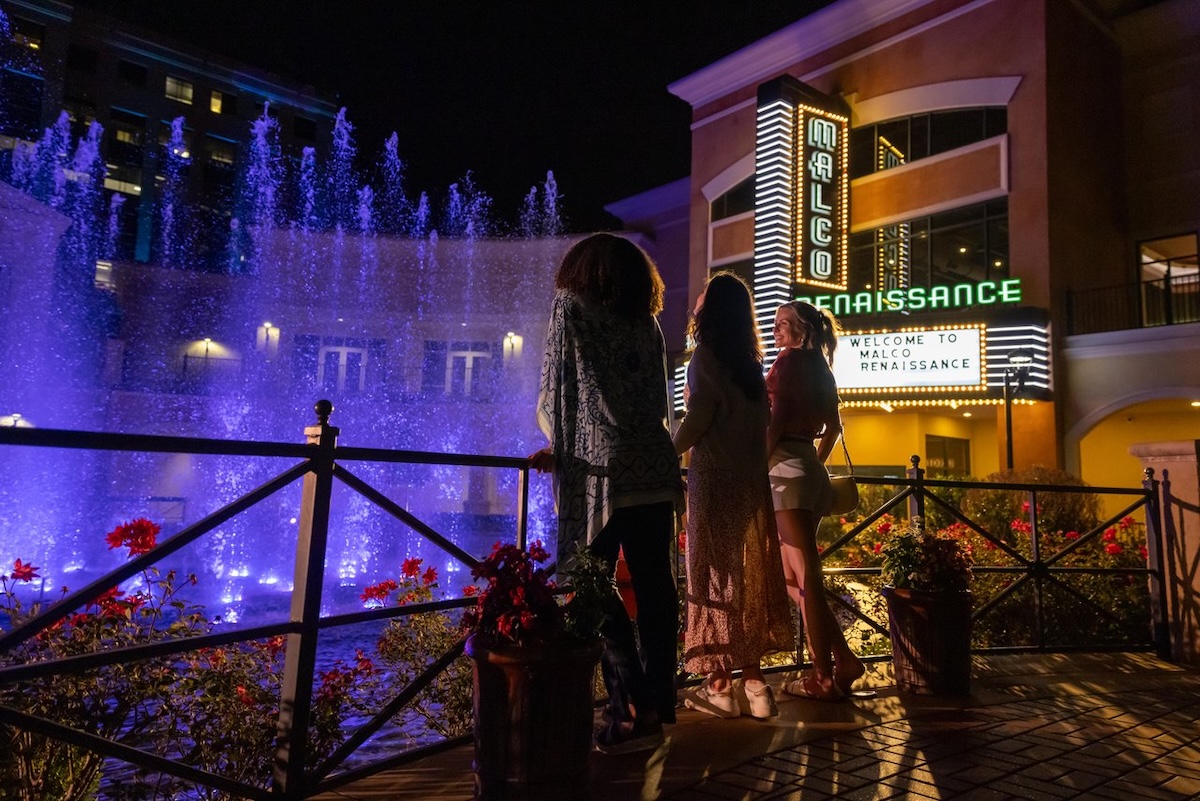 Three women admire the fountain and theater marquee views at night at Renaissance at Colony Park in Ridgeland, Mississippi.
