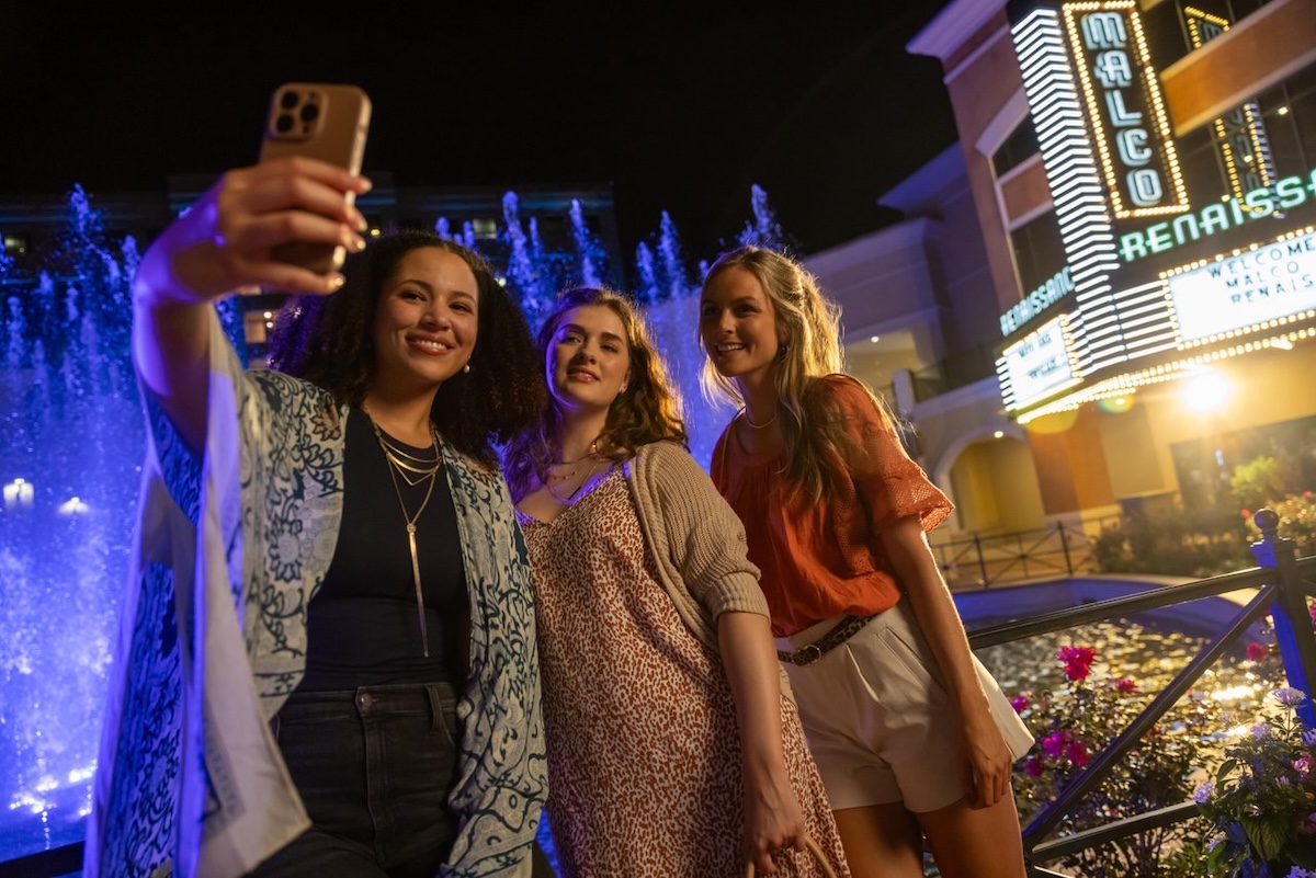 Three women take a photo together in front of the fountain and theater at Renaissance at Colony Park in Ridgeland, Mississippi.
